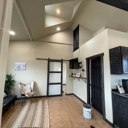 Modern interior of a spacious room featuring high ceilings, a sliding door, and stylish decor.