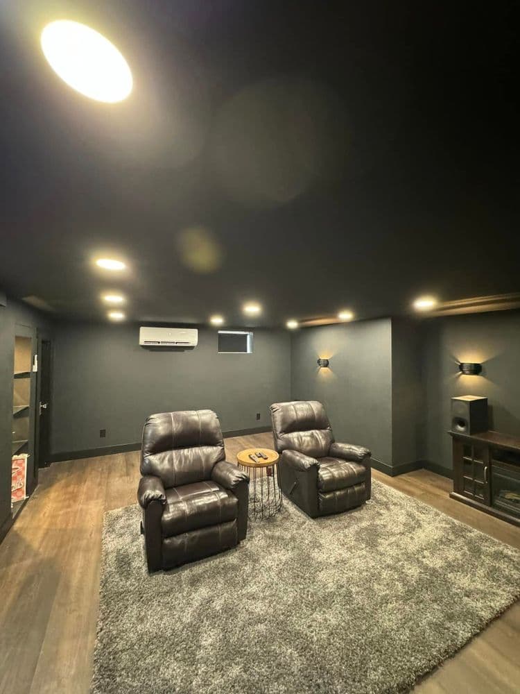 Modern home theater with recliners, gray walls, ambient lighting, and plush carpet.
